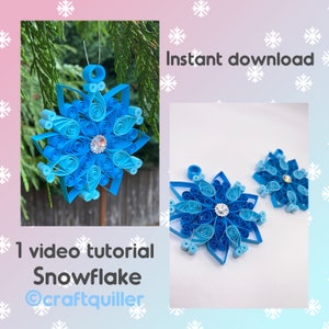 Op de afbeelding: Een video tutorial voor het maken van een blauwe papieren sneeuwvlok versiering. De sneeuwvlok is versierd met een glinsterende blauwe edelsteen in het midden. De afbeelding toont ook twee kleinere sneeuwvlokken.