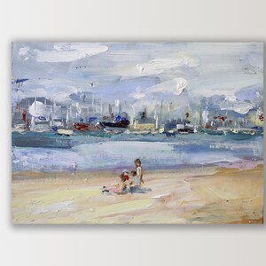 May include: Oil painting of a beach scene with a harbor in the background. The painting features a sandy beach, blue water, and a cloudy sky. Several boats are docked in the harbor. Two children are playing on the beach.