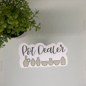 May include: A white sticker with the text "Pot Dealer" in black lettering.  The sticker features a row of seven gray pottery items, including a pitcher, vases, and bowls.