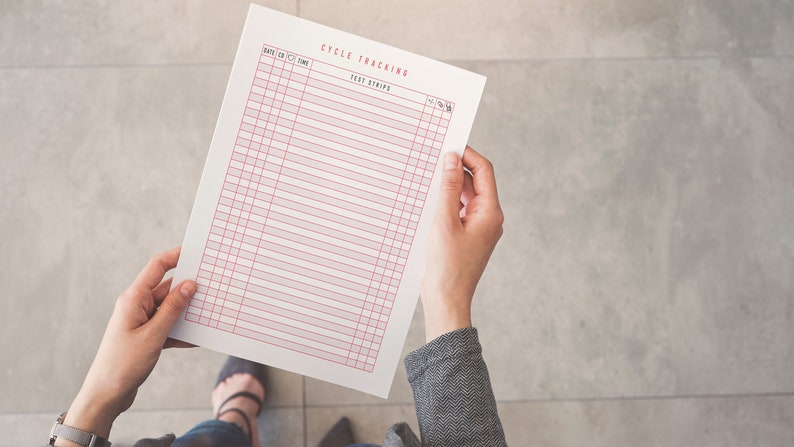 May include: A white printable cycle tracking sheet with red lines. The sheet has columns for date, cervical mucus, ovulation, and temperature. The sheet is titled "Cycle Tracking" and "Test Strips".