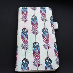 May include: A white phone case with a colourful feather pattern. The feathers are in shades of blue, red, and green. The case has a white strap on the side.