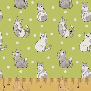 Puede incluir: Tela con un patrón repetido de gatos de dibujos animados en gris y blanco sobre un fondo verde claro con lunares blancos. Una regla en la parte inferior mide en pulgadas, equivalentes a centímetros.