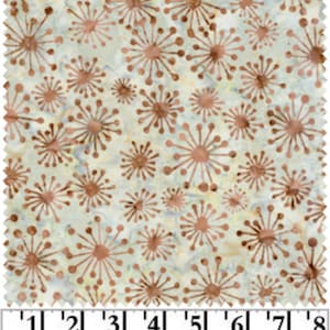 May include: White fabric with a repeating pattern of copper-colored stylized starbursts. The fabric is measured with a ruler in inches.