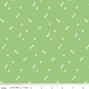 Pode incluir: Um tecido verde com um padrão de pegadas de coelho branco. O tecido é perfeito para projetos de artesanato, quilting e decoração de casa.
