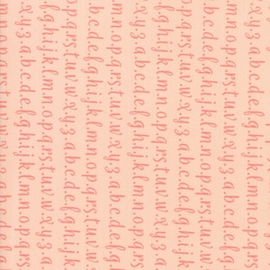 Puede incluir: Una tela de color melocotón con un patrón repetido del alfabeto en color rosa. Las letras están escritas en un estilo informal y manuscrito.