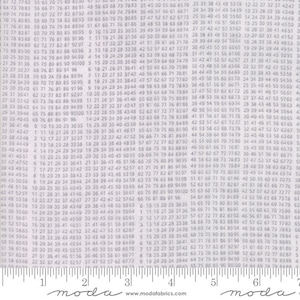 以下が含まれることがあります： グレーと白の生地で、数字が繰り返しパターンになっています。生地はModaの生地で、ウェブサイトはwww.modafabrics.comと記載されています。