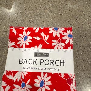 May include: A stack of fabric squares with a red background and white daisy floral pattern. The fabric is labeled "Back Porch" by Me & My Sister Designs.