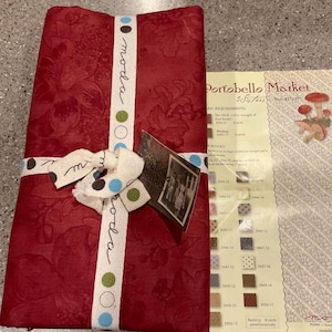 May include: A white ceramic mug with a black handle and the text "But First, Coffee" in a black, handwritten font. The mug is on a white surface.