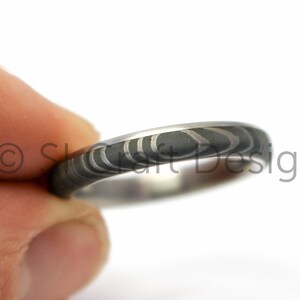 Stainless Damascus ring with a overlapping Titanum sleeve
