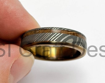 Stainless Damascus ring with a overlapping Titanum sleeve and wooden inlay, anodised various colours