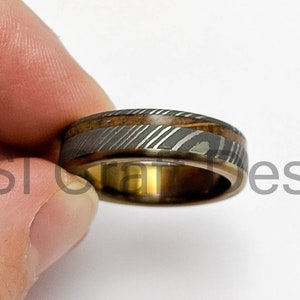 Stainless Damascus ring with a overlapping Titanum sleeve and wooden inlay, anodised various colours