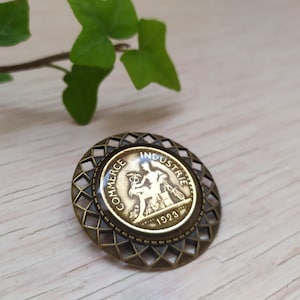 Round bronze-colored brooch with 1923 coin in resin inclusion