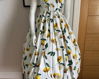 Precioso vestido de falda amplia con estampado novedoso de limones estilo años 50.