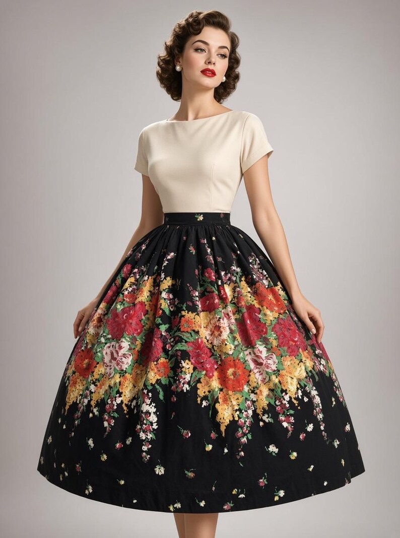 May include: A dress featuring a cream-colored short-sleeved bodice with a boat neckline and a high-waisted, full-length black skirt. The skirt is decorated with a vibrant, multi-colored floral print in shades of red, yellow, and green.