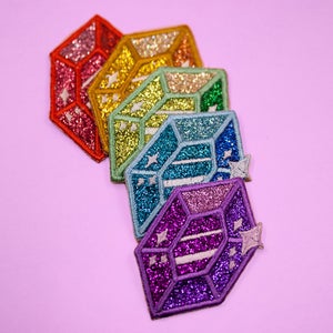 Könnte beinhalten: Ein Set mit sechs glitzernden, regenbogenfarbenen, gemmenförmigen Bügelbildern. Die Patches sind in Regenbogenreihenfolge von Rot bis Lila angeordnet.