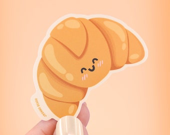 May include: A yellow cartoon croissant sticker with a cute smiling face. The sticker has a white outline and is slightly curved. The text "Joining Belair" is printed on the bottom of the sticker.