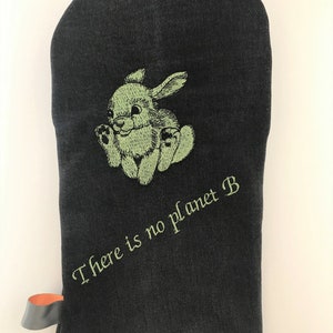 May include: Black oven mitt with a green embroidered bunny and the text "There is no planet B".