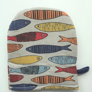 Pode incluir: Uma luva de forno cinza com um padrão de peixe colorido. Os peixes são em tons de vermelho, laranja, amarelo, azul e verde.