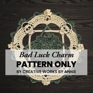 May include: A crochet doily with a green and white pattern. The doily is round and has a floral design. The text "Bad Luck Charm PATTERN ONLY BY CREATIVE WORKS BY ANNIE" is printed on a black rectangle.