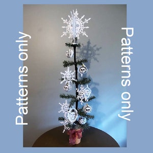 May include: A small artificial Christmas tree decorated with white crocheted snowflakes and skull ornaments. The tree is in a brown pot with a red ribbon.