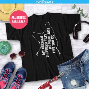 Può includere: Maglietta nera con una silhouette bianca della testa di un pastore tedesco e il testo "My German Shepherd Tilts Its Head Just Like You Do".