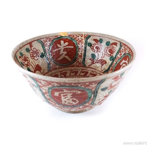 Könnte beinhalten: Eine weiße Keramikschüssel mit roten und grünen Blumendesigns und chinesischen Schriftzeichen. Die Schüssel hat einen leicht abgebrochenen Rand.