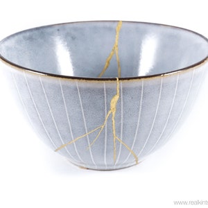 May include: A gray ceramic bowl with gold crackle lines. The bowl has a textured, ribbed surface.