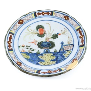 May include: A blue and white ceramic plate with a floral design. The plate has a scalloped edge and a brown and yellow border.