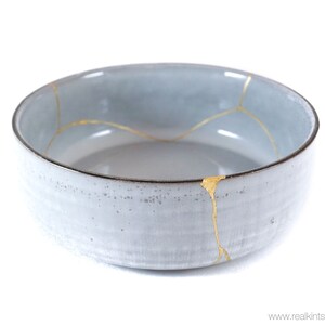 Op de afbeelding: Een grijze keramische kom met gouden scheuren. De kom is in traditionele Japanse kintsugi-stijl.