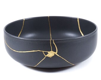 Kintsugi, contemporary black bowl, restoration with real 22K gold, Kintsukuroi technique, symbol of resilience and overcoming a trauma.