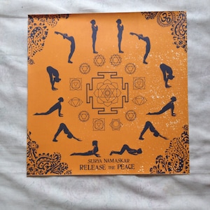 May include: Orange square print featuring yoga poses in navy blue. The print includes the text "SURYA NAMASKAR RELEASE THE PEACE" and various geometric and floral designs. The yoga poses are arranged in a circular pattern.