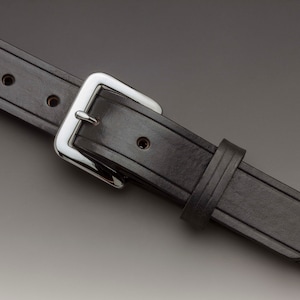 May include: A black leather belt with a silver buckle. The belt has multiple stitching details and a pointed end.