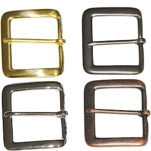 May include: Four metal belt buckles in different finishes: gold, black, silver, and copper. Each buckle has a square shape with a rectangular center opening and a smaller rectangular bar across the center.