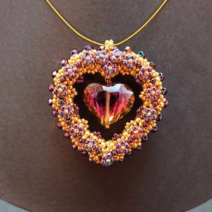 May include: A gold chain necklace with a heart-shaped pendant made of iridescent purple and gold beads. The pendant features a clear, faceted crystal in the center.