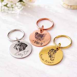May include: Three engraved pet ID tags with key rings. A silver tag shows a dog portrait and the name "Betty Boo." A copper tag displays a cat portrait and the name "Mazi." A gold tag shows a horse and the name "Saxon Prince."