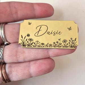 May include: A white ceramic mug with a black handle and the text "But First, Coffee" in a black, bold font. The mug is on a white surface.