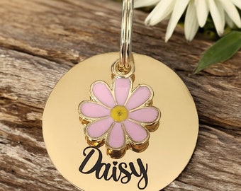 Gold pet ID tag with pink or blue daisy charm.