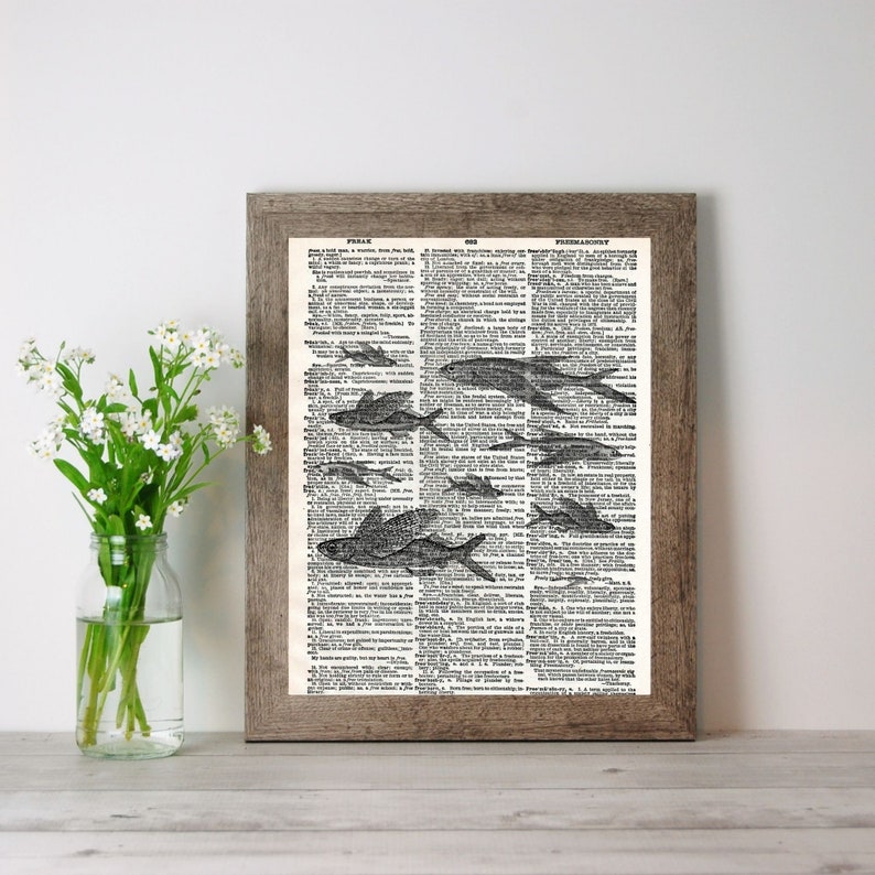 Puede incluir: Una p&aacute;gina de diccionario vintage con una ilustraci&oacute;n en blanco y negro de un banco de peces nadando. La p&aacute;gina est&aacute; enmarcada en un marco de madera marr&oacute;n. El texto en la p&aacute;gina dice "FISH.  ...  PISCI-CULTURE."