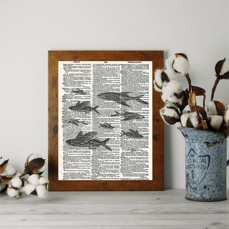 Puede incluir: Una p&aacute;gina de diccionario vintage con una ilustraci&oacute;n en blanco y negro de un banco de peces nadando. La p&aacute;gina est&aacute; enmarcada en un marco de madera marr&oacute;n.