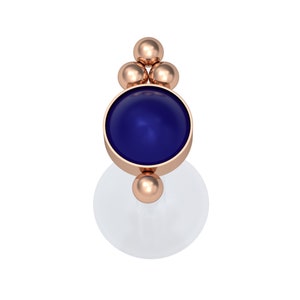 May include: A rose gold body jewelry stud featuring a central circular deep blue stone. The setting includes a cluster of three small rose gold spheres at the top and one single rose gold sphere at the bottom, attached to a clear flat circular base.