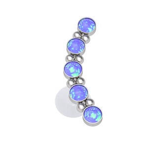 May include: A curved body jewelry piece featuring four circular, iridescent blue opal cabochons set in silver-toned metal. The stones are arranged in a vertical arc, separated by small, polished silver-toned metal spheres along the curved frame.