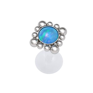 Könnte beinhalten: Ein Körperschmuckstück aus Silber mit einem blauen Opal-Edelstein, umgeben von einem Heiligenschein aus kleinen silbernen Perlen.
