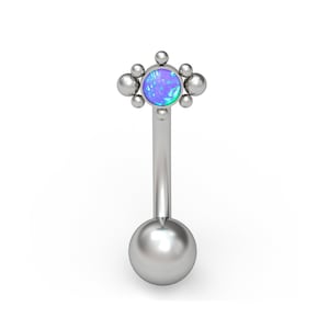 May include: Silver body piercing with a cluster of small balls surrounding a blue opal gemstone. The piercing has a smooth, round ball on the other end.