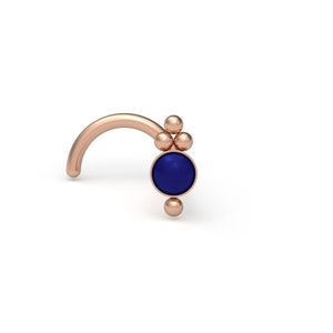 May include: A rose gold nose ring with a cluster of small beads and a blue gemstone.