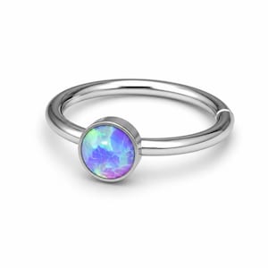 May include: A circular silver-toned hoop ring featuring a single round bezel-set cabochon stone. The stone displays an iridescent play of colour with vibrant hues of blue, purple, and green, set within a polished metallic band with a hinged closure.
