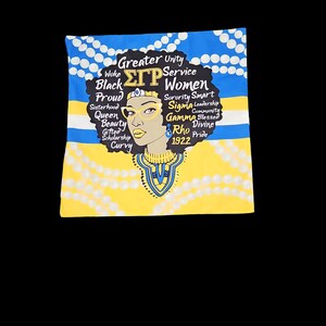 May include: A yellow and blue pillow with a black and white illustration of a woman with a crown and glasses. The text "Greater Unity", "Woke", "Black", "Proud", "Sisterhood", "Queen", "Beauty", "Gifted", "Scholarship", "Curvy", "Service", "ΣΓΡ Women", "Sorority", "Smart", "Sigma", "Leadership", "Community", "Gamma", "Blessed", "Rho", "Divine", "1922", "Pride" is printed on the pillow.
