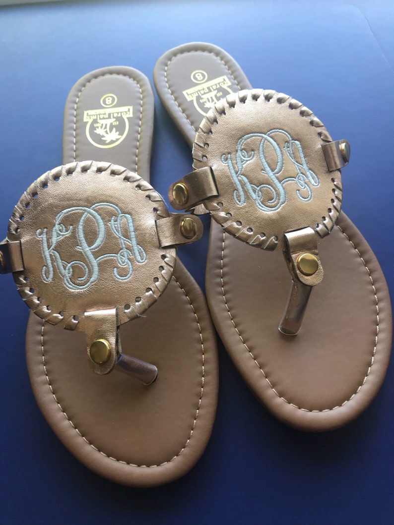 flip flops with gold medallion