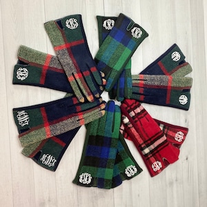 May include: Eight pairs of plaid fleece gloves with monogrammed initials. The gloves are in various colors including red, green, blue, and black.
