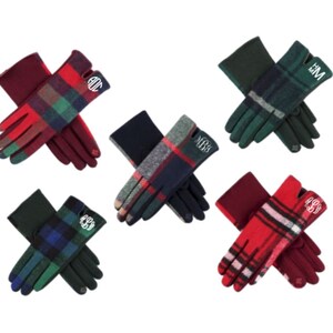 Pu&ograve; includere: Cinque paia di guanti in pile a quadri con diverse iniziali di monogramma. I guanti sono rossi, verdi e blu.