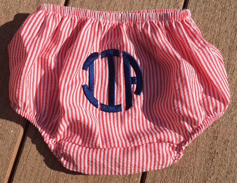 May include: Red and white striped baby bloomers with a blue embroidered monogram "J.J.A."